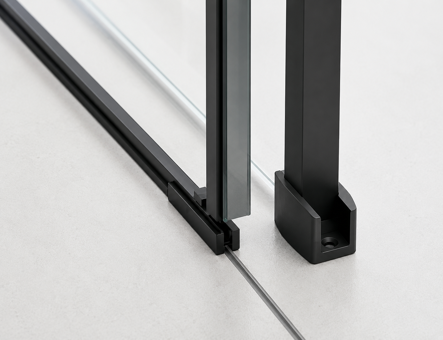 Close-up of a black sliding door track system on a glass panel.